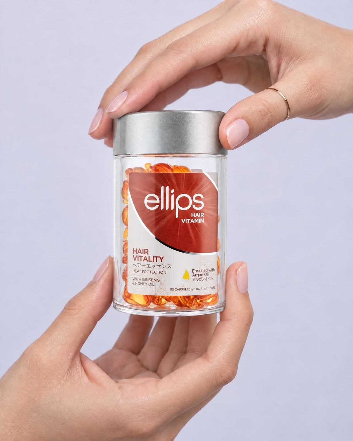 Kaksi kättä pitelee Ellips Hair Vitality -purkkia