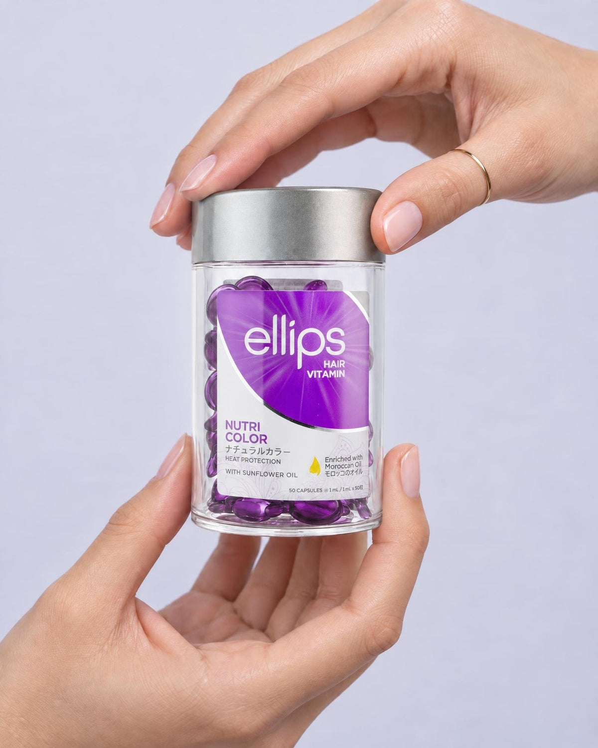 Kaksi kättä pitelee Ellips Nutri Color -purkkia