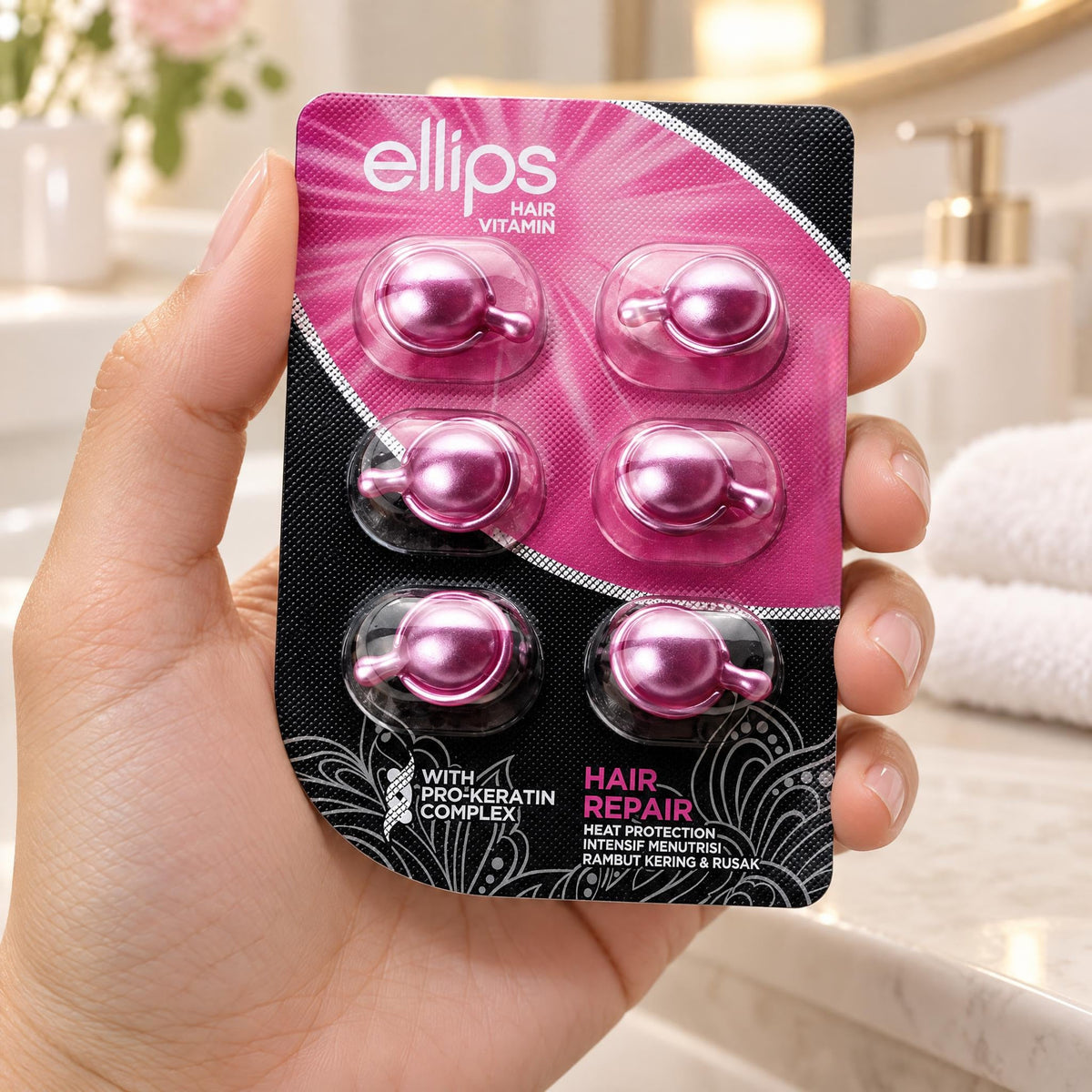 Kädessä Ellips Hair Repair -kokeilukoko, jossa on 6 kapselia