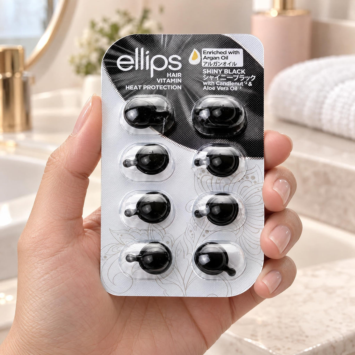 Kädessä Ellips Shiny Black -kokeilukoko, jossa on 8 kapselia