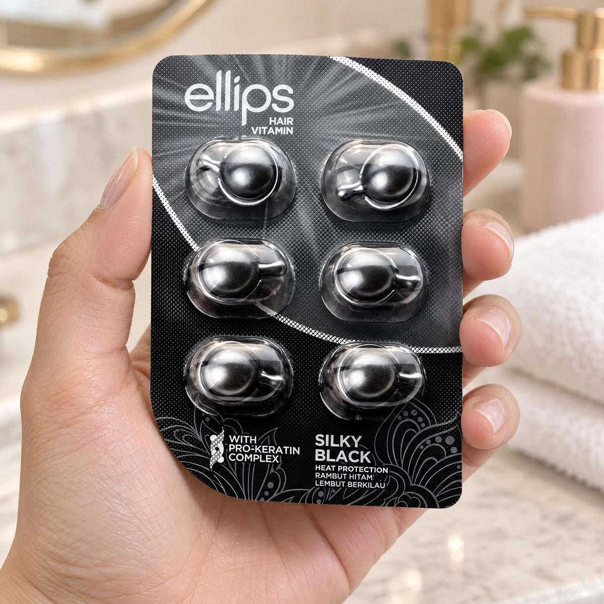 Kädessä Ellips Silky Black -kokeilukoko, jossa on 6 kapselia